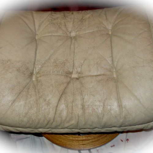 A tired and worn leather ottoman