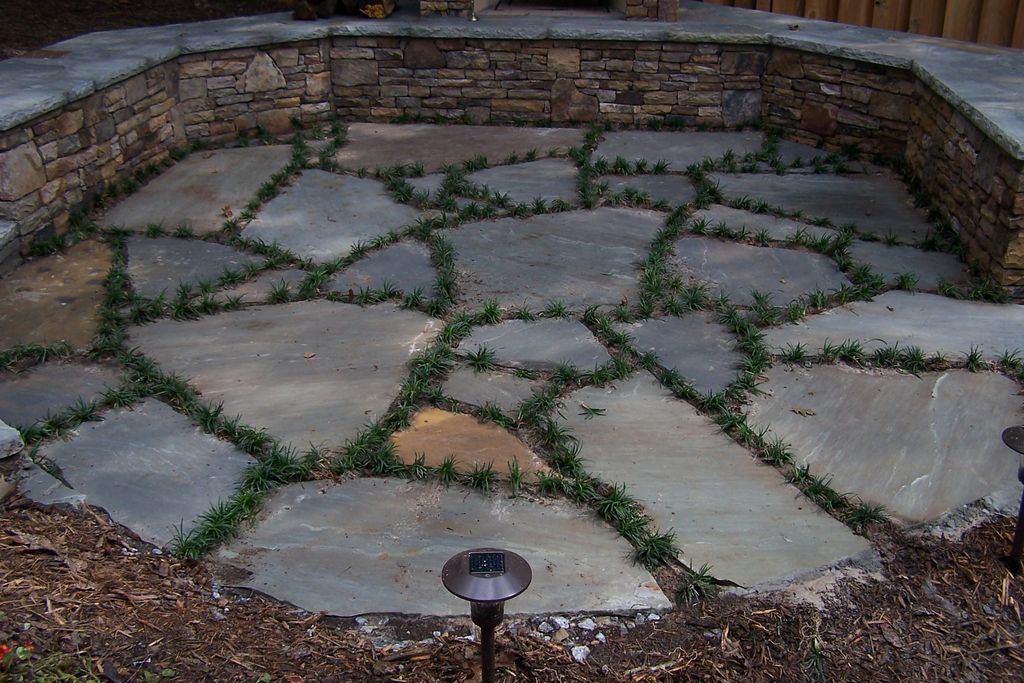 Large grey flag stone patio with dwarf mondo grass