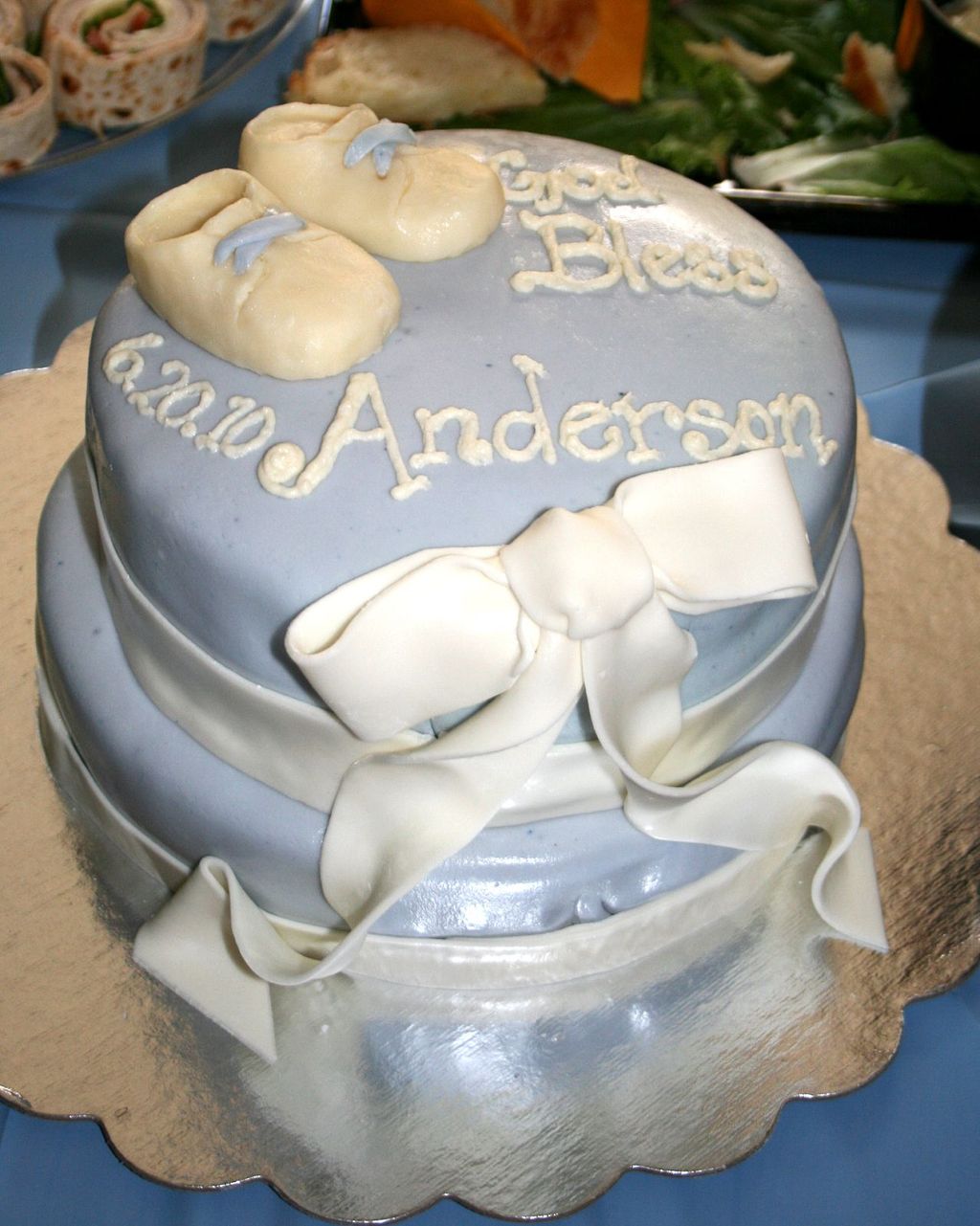 Two-tier fondant-covered baptism cake featuring wh