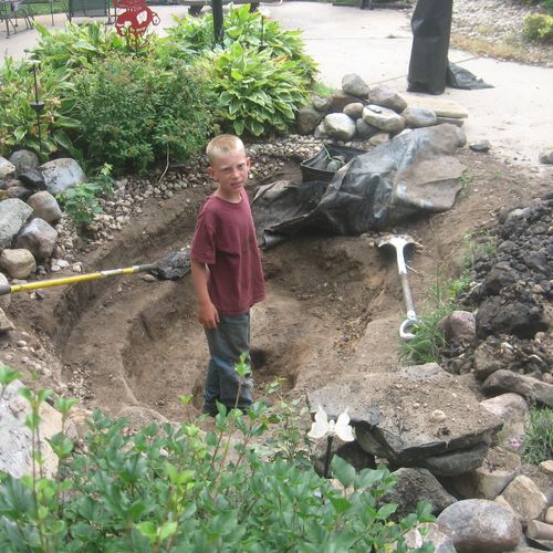 my son standing in a pond we are redoing for a ver