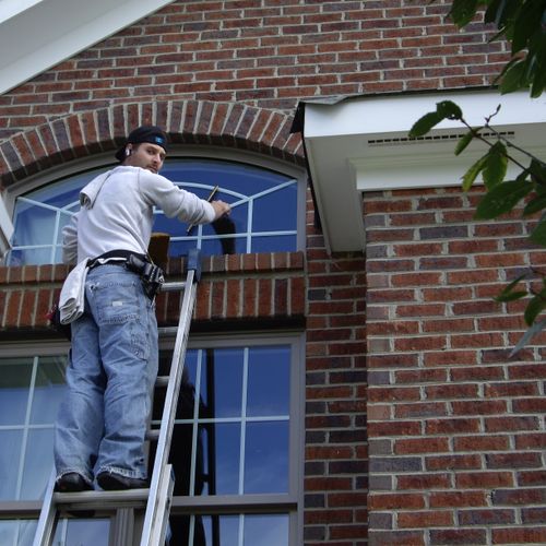 My son cleaning windows at a home on a golf course