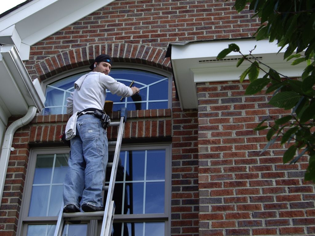 My son cleaning windows at a home on a golf course