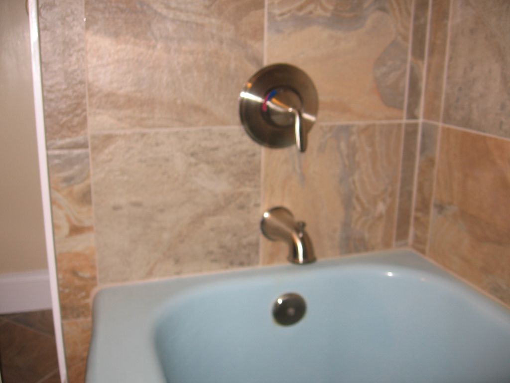 New tile and shower valve on existing blue tub.