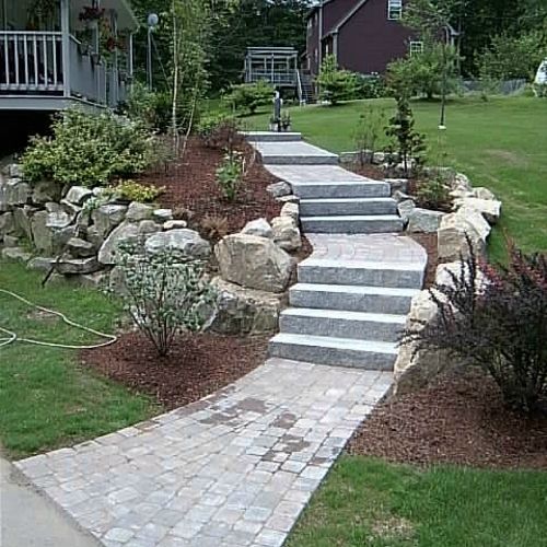 Concrete paver walkway with granite steps lined wi