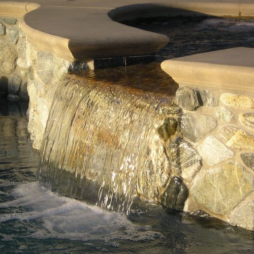 Spa spill way with native river rock and custom po