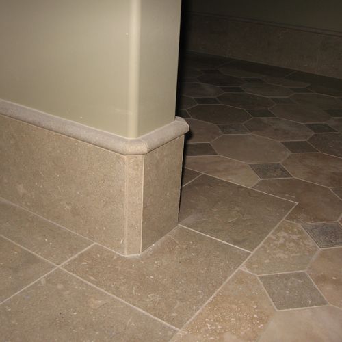 Stone capped-baseboard with radius corners over oc