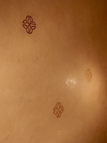 Decorative plaster with raised metallic stencil.