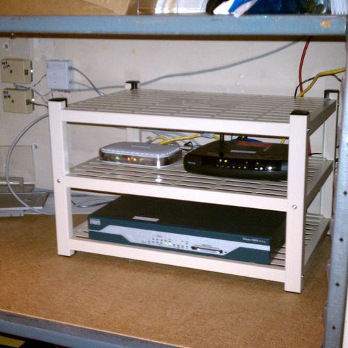 Small Communications rack for a retail store featuring a Cisco VPN router, DSL modem and a fast ethernet switch.