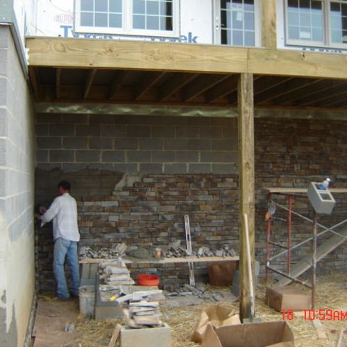 Installing rock around block foundation.