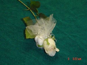White silk rose with white almonds in netting.
