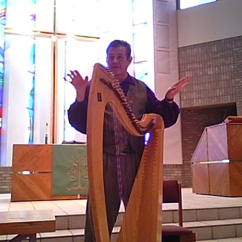 Explaining the harp and its history before a group