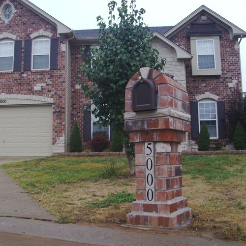 Brick mailbox with stone accents.