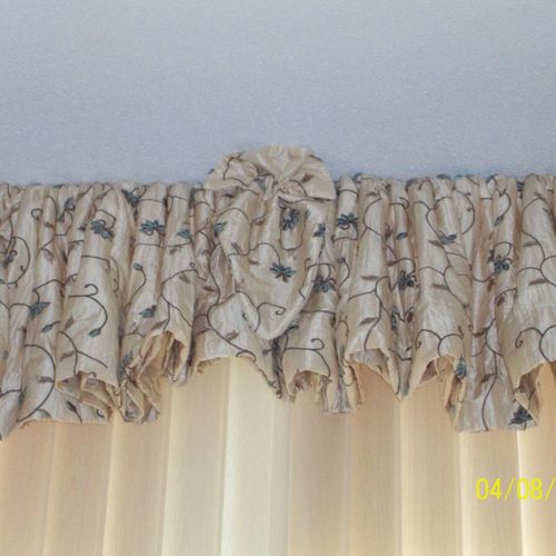 A pretty shaped valance with a center accent, to m