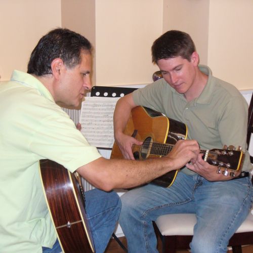 Peter King, left, teaching a guitar student in his