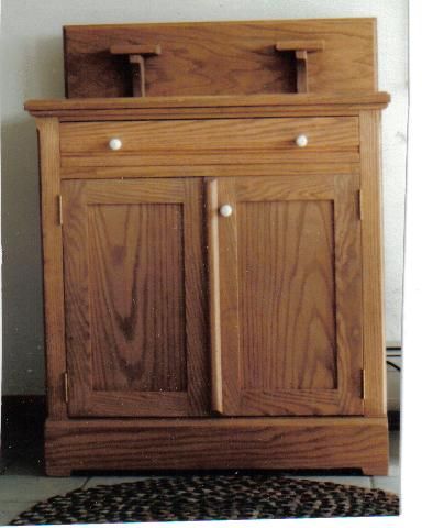 This is an antique reproduction of an oak commode.