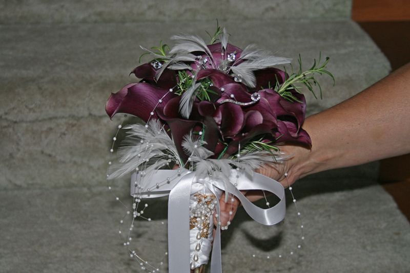 Bridal bouquet of dark calla lilies and feathers.