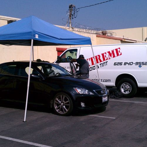 Xtreme Audio and Tint appling window tint to a car