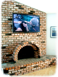 TV mounted above fireplace on brick wall.