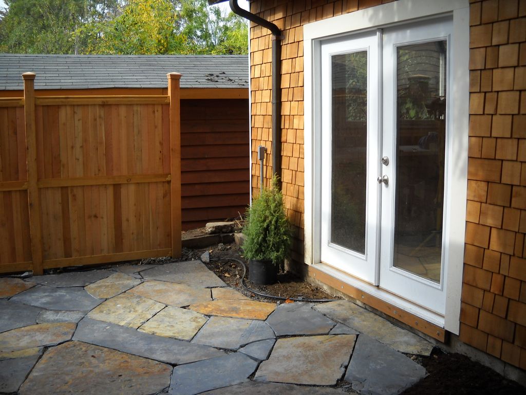 Garage after new siding, door, fence and patio