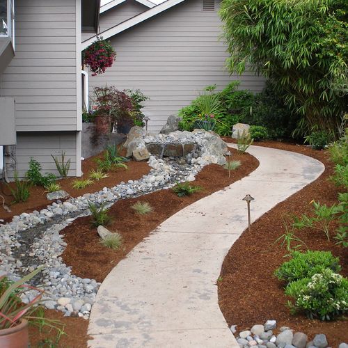 Concrete sidewalk pondless water feature with outd