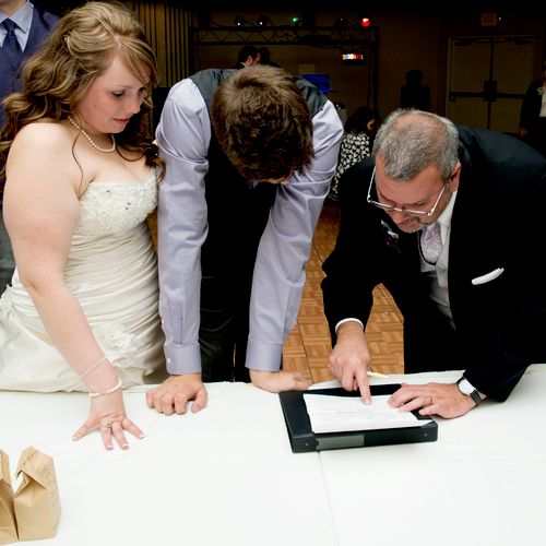Signing marriage license with bride and groom.