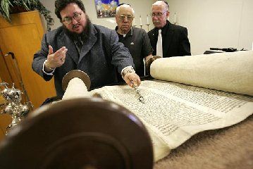 Reading from a 17th century Torah that survived th