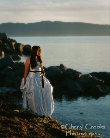 A senior wearing her prom dress on the beach makes