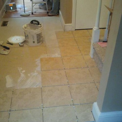 Working on laying tile in foyer