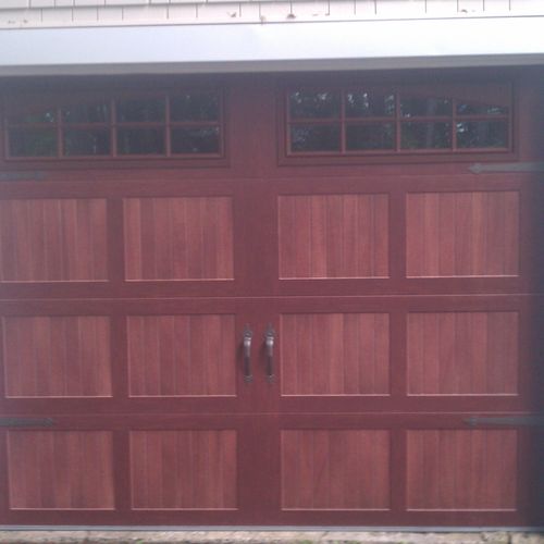 Insulated steel door with stained wood look.