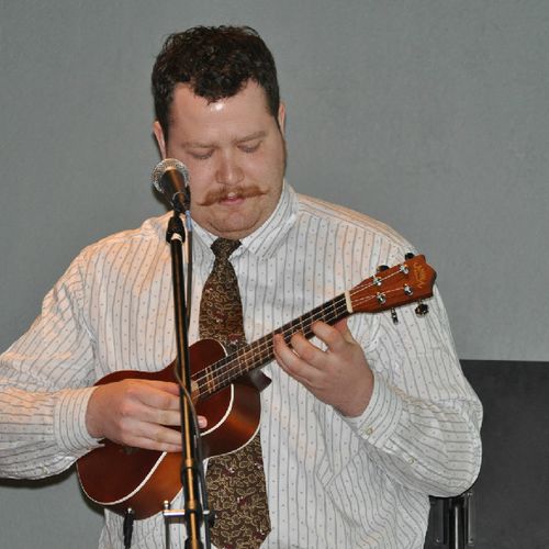 Co-owner and instructor, Drew Bradley, playing uku