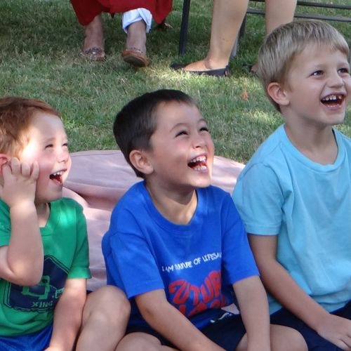 Children at a birthday party laughing to the antic