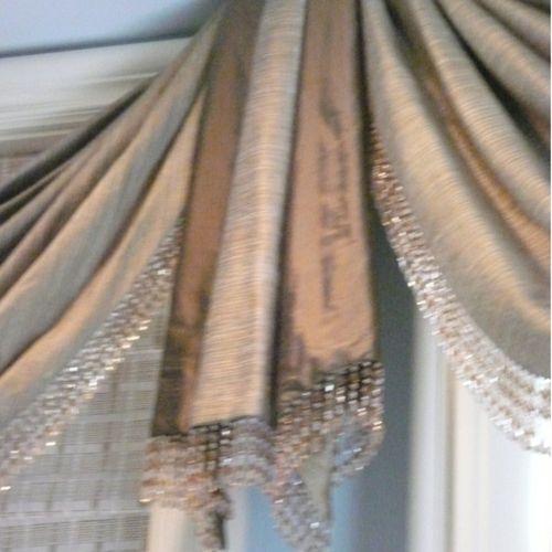 Softly pleated swags, jabots, beads and woven wood