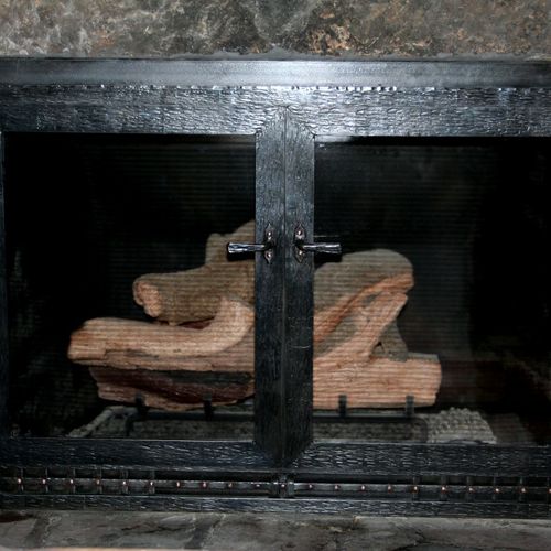 A forged iron and copper Craftsmen style fireplace
