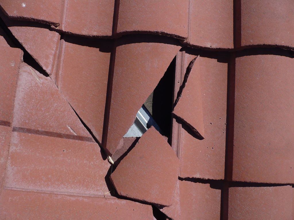 Broken concrete roof tile, exposing roof underlaym