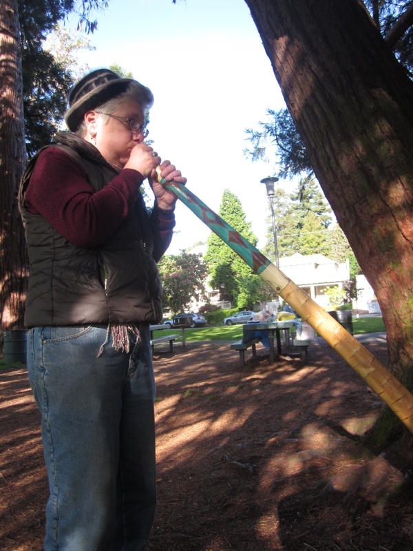 Elise playing yucca didge in a ceremony