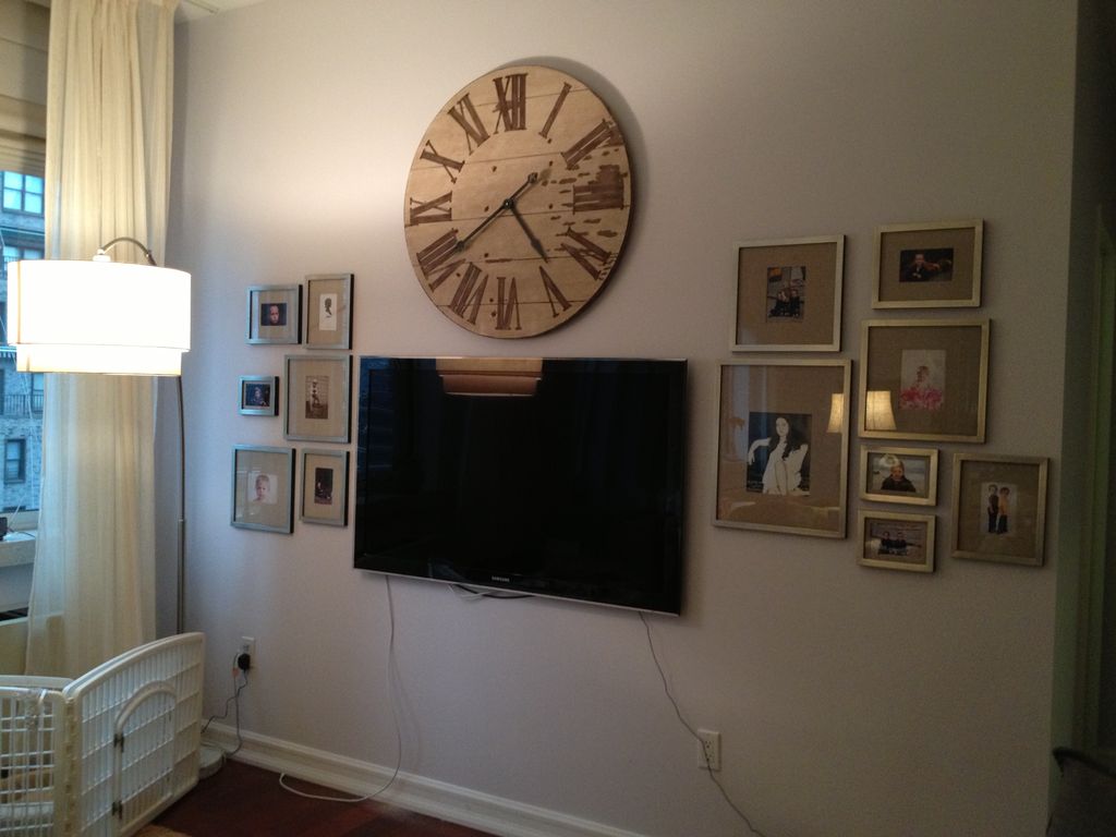 Flat screen TV and wall clock bracketed by photo c