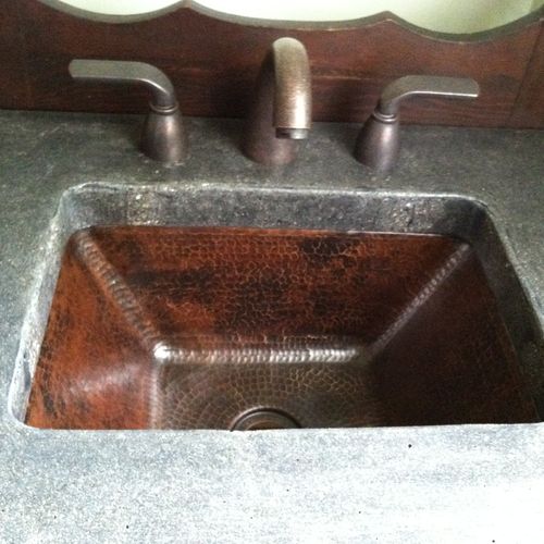 Antique vanity with brass sink and concrete counte