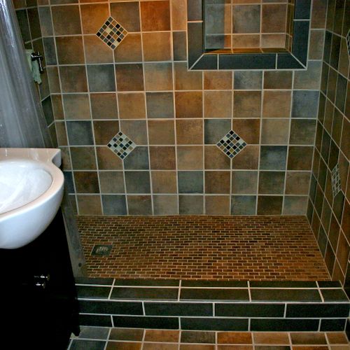 Tiled walk-in shower stall with product alcove by 