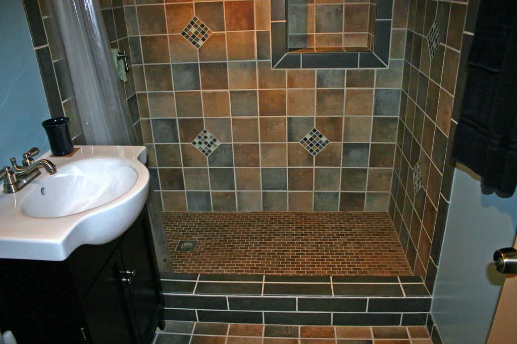 Tiled walk-in shower stall with product alcove by 