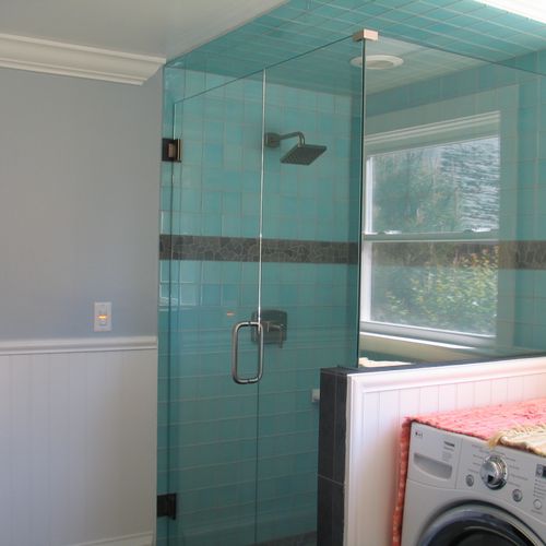 Glass tile shower with stone accent and shower pan