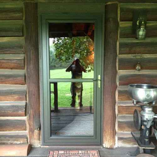 Storm door installation on a log cabin.