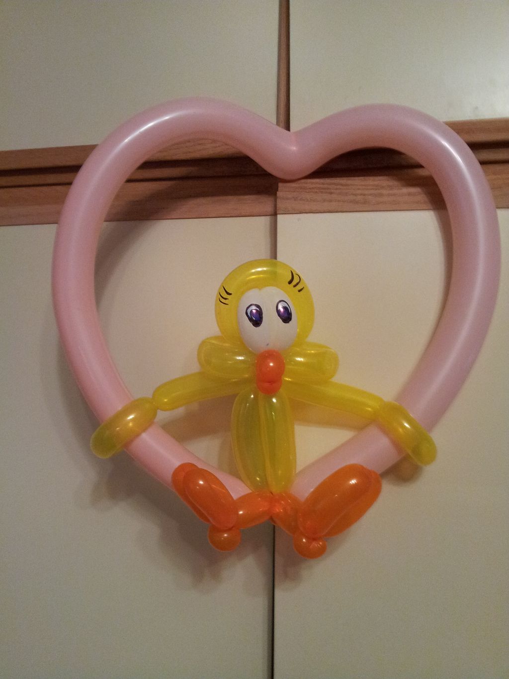 A cute birdie swinging on a heart.