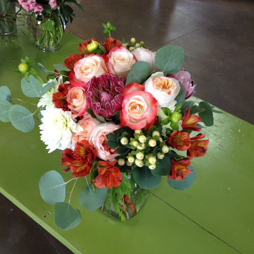 A bridal bouquet with pink protea, peach garden ro