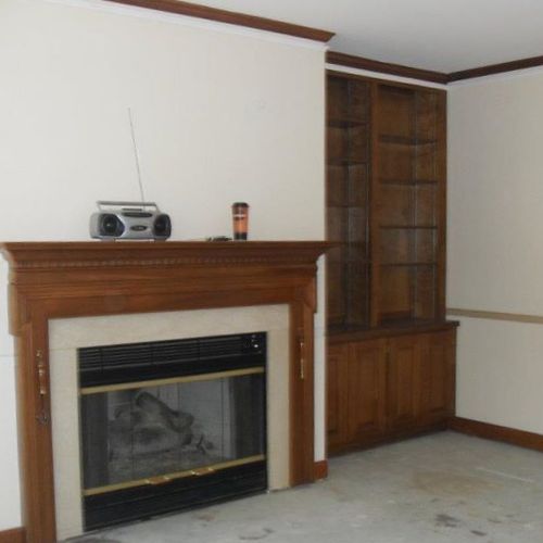Before of fireplace, bookcases and walls.
