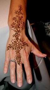 An elaborate henna tattoo on hand and wrist.