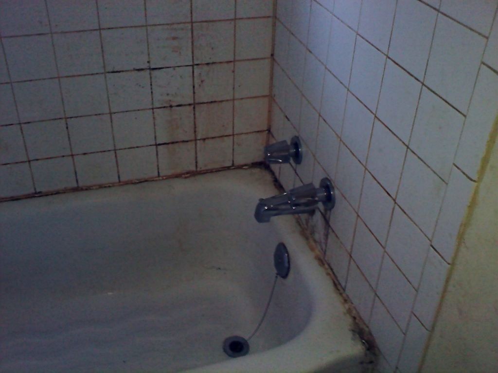 Uncleaned residential bathroom wall and tub #2