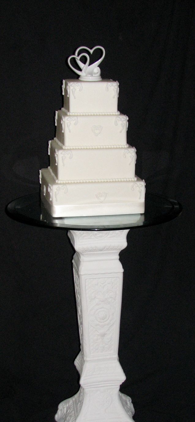 Tiered wedding cake with fondant design and pedest