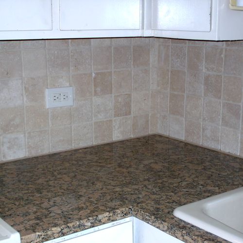 Travertine tile  and  a granite countertop made th