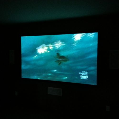 102" Projection screen with on-wall speakers.