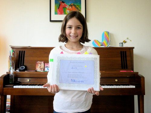 Iris smiles with her piano certificate!